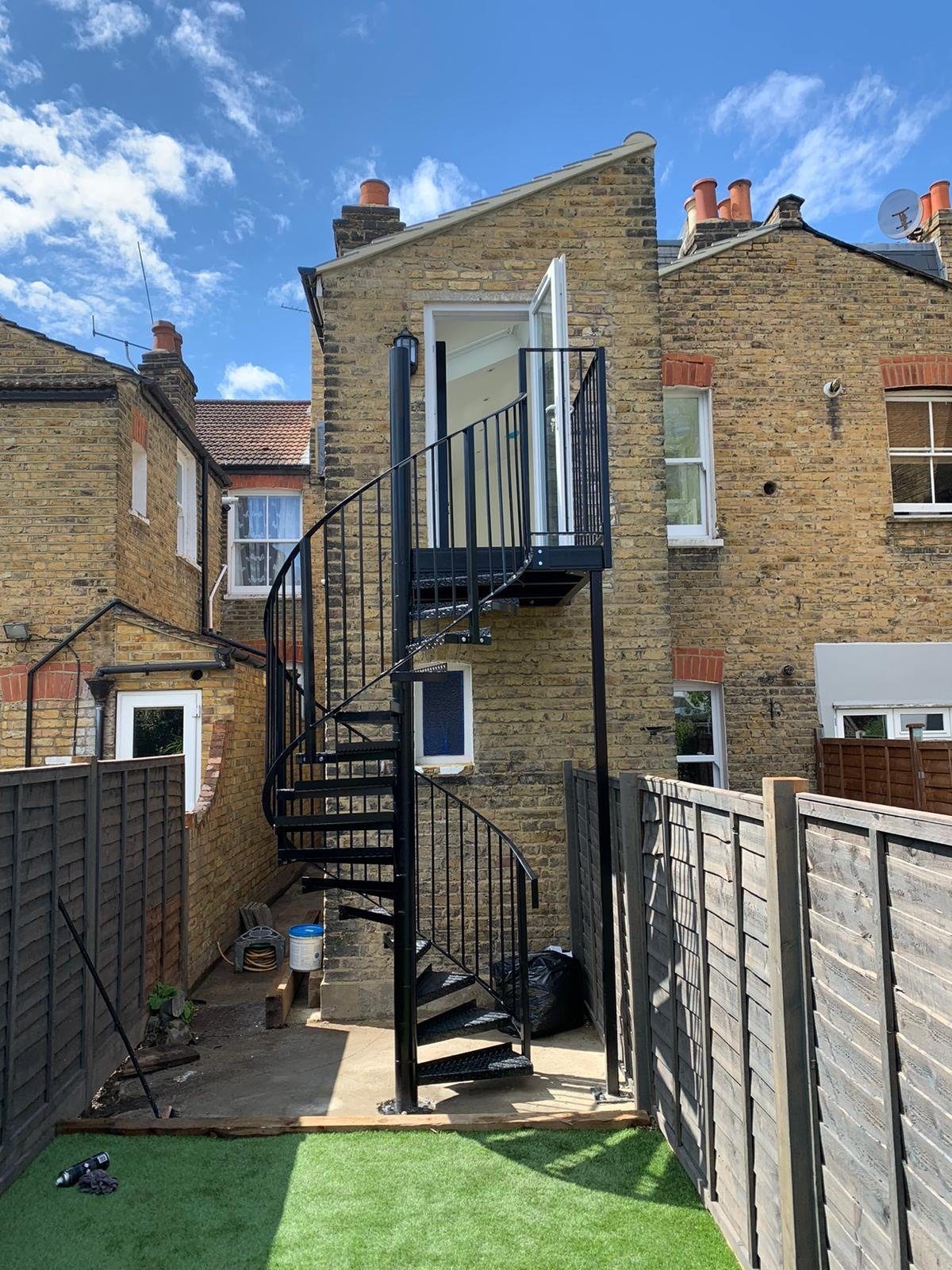 Black steel spiral staircase at the rear of a London house